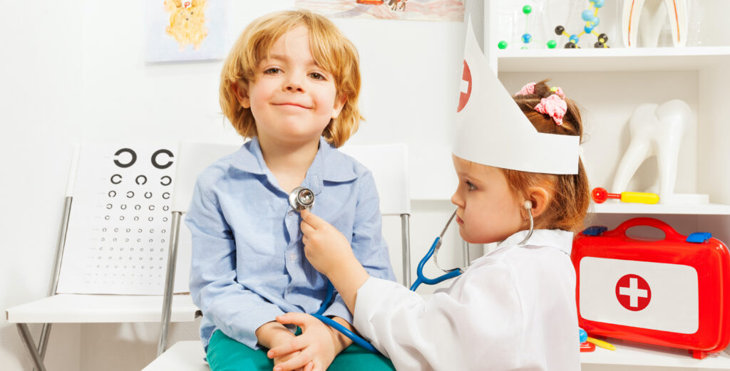 Little girl dressed like a doctor examining boy with stethoscope