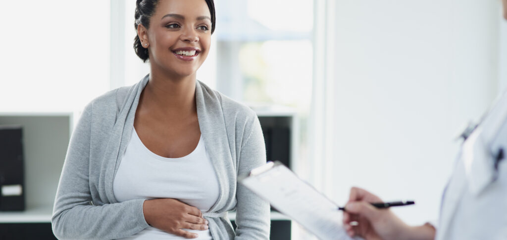 A female doctor consulting with a pregnant patient about FASD prevention at a hospital during the day. 