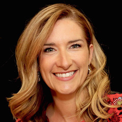 Headshot of Maude Champagne, smiling against a black background