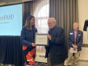Doug awarding Lisa Murphy of the Lakeland Centre for FASD a certificate for the Claudette Bradshaw FASD Innovation Award