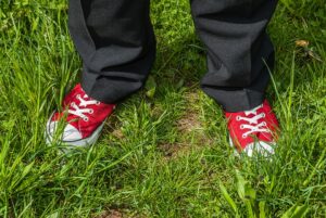 Close up of person in red shoes standing in grass