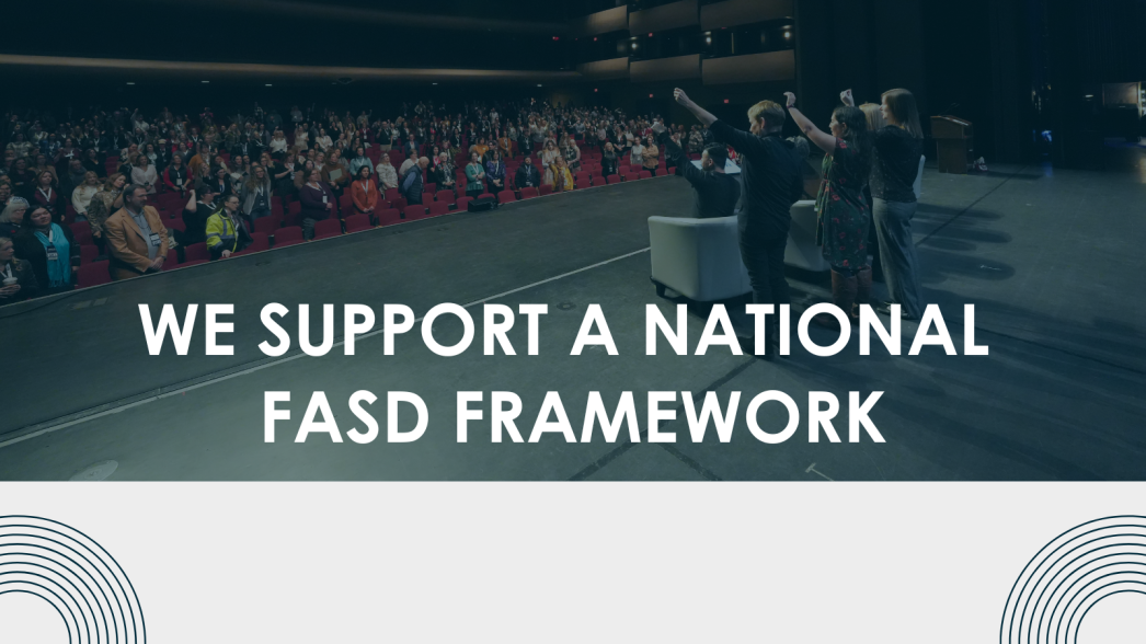 Group of people stand raising their arms in front of an audience with text reading 'we support a National FASD Framework'