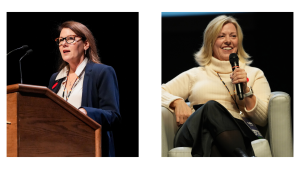 Two women speaking at a professional event. The woman on the left, wearing a navy blazer, white blouse, and glasses, is standing behind a wooden podium, addressing an audience. She has a serious and focused expression. The woman on the right, dressed in a cream turtleneck sweater and black skirt, is seated in a panel discussion setting, holding a microphone and smiling while speaking. Both women are wearing lanyards with identification badges, indicating a conference or formal gathering.